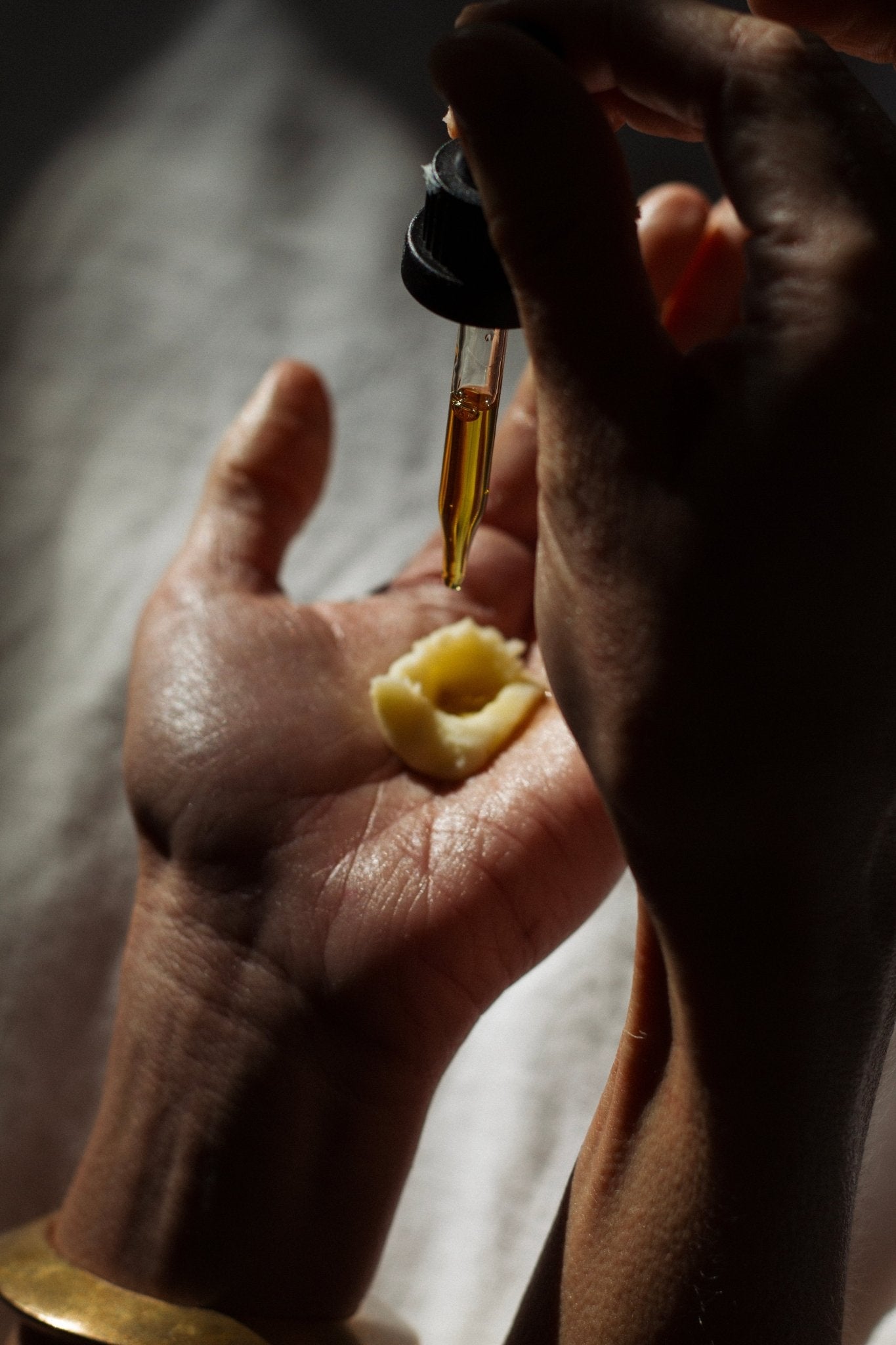 Applying tallow and emu oil face oil during a gua sha ritual